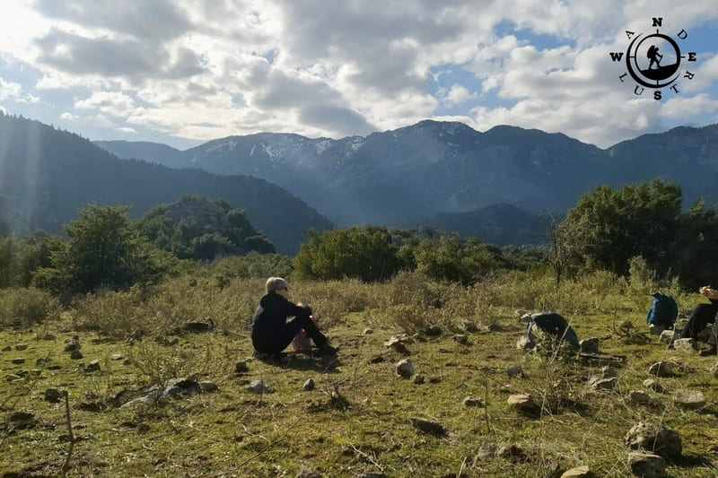 Πεζοπόροι σε ξέφωτο με θέα στις δασωμένες βόρειες πλαγιές του Παρνασσού, στη διαδρομή Αγόριανη–Πολύδροσος.