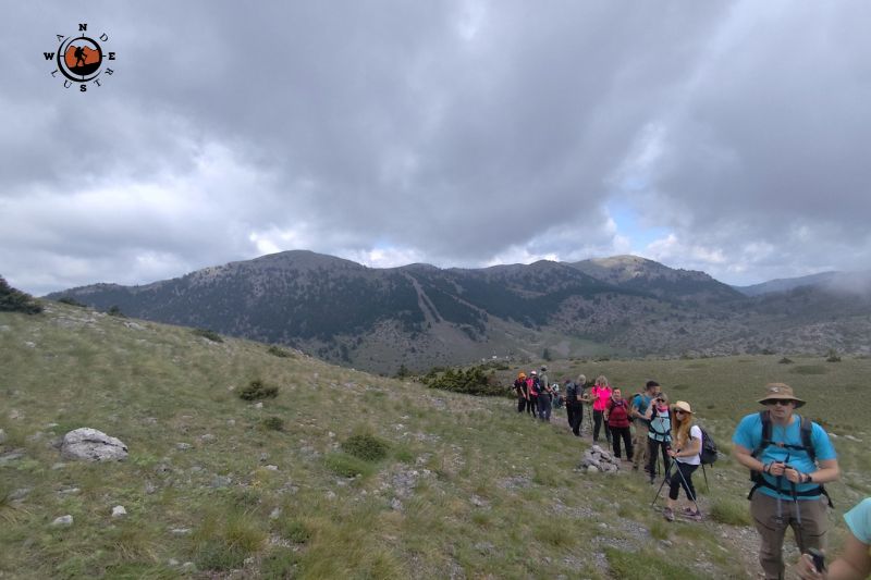 Ομάδα πεζοπόρων διασχίζει τις ανοιχτές ορεινές πλαγιές του Μαινάλου