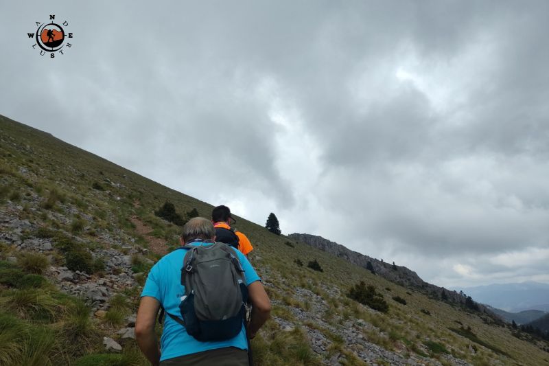 Πεζοπόρος ανεβαίνει σε βραχώδες μονοπάτι στις πλαγιές του Μαινάλου