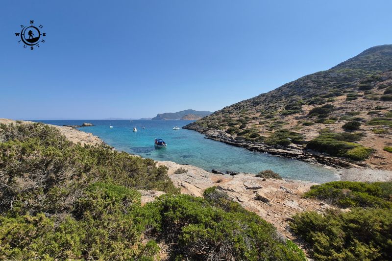 Small rocky cove with turquoise water and low vegetation at the foot of Perati